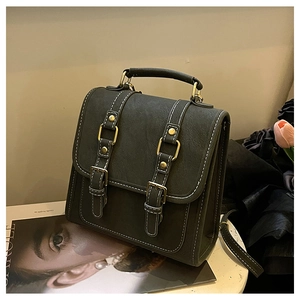 Détail d'un sac à dos en cuir litchi avec coutures blanches et garniture dorée