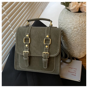 Vue détaillée du sac à dos vintage olive foncé avec d'élégantes boucles dorées