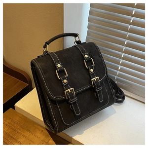 Détails du sac à dos en daim noir avec coutures contrastées blanches et boucles dorées