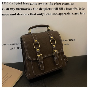 Gros plan d'un sac à dos vintage marron foncé avec texture mate et boucles dorées