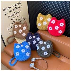 Detail view of plush cat-shaped bucket bags with flower embroidery in various colors
