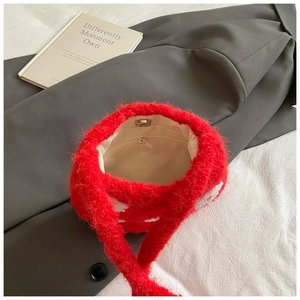 Detailed interior of red plush bucket bag with magnetic closure and zip pocket