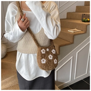 Detail of soft brown plush bucket bag with cute white 3D knitted flower embroidery