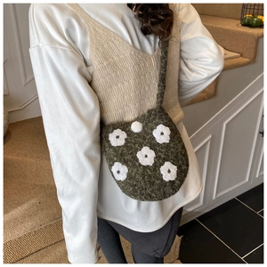 Detail of moss green fuzzy knit crossbody bag with white flower embroidery for winter