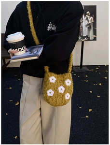 Detailed view of yellow plush bucket bag with cute flower embroidery on soft fabric