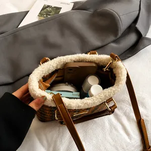 Vista interior del bolso de cuadros con ribete de borreguito y gran capacidad interna