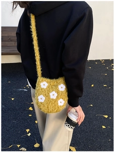 Detail of yellow plush bucket bag with embroidered white flowers for autumn winter outfits