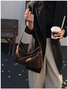 Detail of leopard print underarm bag with leather trim and metal eyelets in autumn style