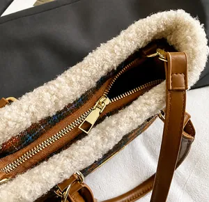 Detalle del bolso tipo cubo con herrajes dorados y textura de ribete de borreguito blanco