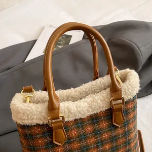 Detalles de la textura a cuadros y el ribete de lana suave en un bolso tipo cubo chic