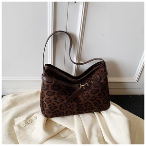 Detail of vintage leopard print suede bucket bag with gold metal clasp and brown leather strap