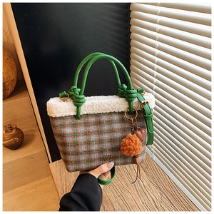 Détail du sac à main à carreaux avec bordure en laine d'agneau et pompon orange