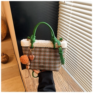 Détail du sac seau à carreaux en peluche avec poignée nouée sur surface en bois