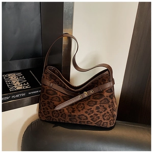Detail of leopard print faux fur shoulder bag with brown leather strap and gold hardware