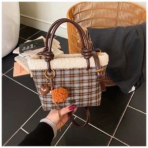Gros plan du sac à main à carreaux avec bordure en peluche et pendentif en forme de cœur
