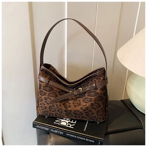 Detail of vintage leopard print suede shoulder bag with brown leather strap and buckle