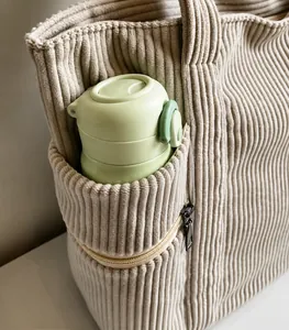 Nahaufnahme der beigen Cord-Tasche mit Reißverschluss-Seitentasche und Trinkflasche