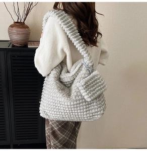 Detail of grey plush tote bag with quilted texture and matching mini detachable pouch