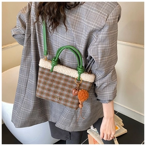 Détail du sac en laine à carreaux avec bordure en fausse fourrure et breloque coeur