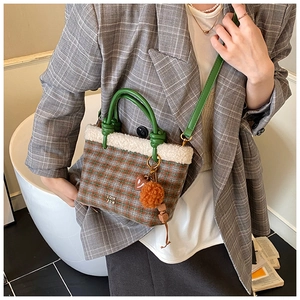 Sac seau à carreaux avec bordure en fausse fourrure porté en bandoulière avec breloques