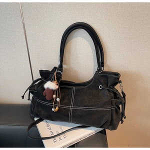 Detail of black tote bag with white contrast stitching and creative glove ornament