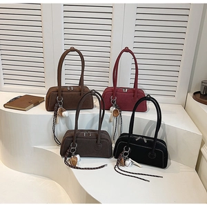 Close-up of matte Boston bags in four colors with distinctive baseball keychains