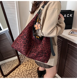 Detalle de bolso hobo de leopardo con colgante de flor de madera en la correa ancha
