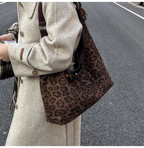Detalle de bolso hobo de leopardo con correa de cuero marrón y cuentas de madera