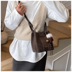 Detail of dark brown bucket bag with contrast stitching and festive glove charm