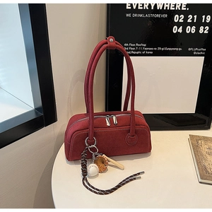 Close-up of dark red vintage frosted boston bag with premium baseball theme pendant