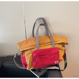 Detail view of the contrasting yellow and red large travel bag with side drawstring details