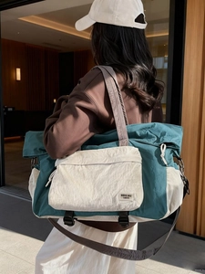 Large capacity canvas travel bag with teal and cream contrast panels and shoulder strap