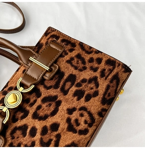Detail of leopard print handbag with golden heart clasp and premium texture
