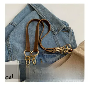 Detail of premium brown leather and gold metal chain shoulder strap on tote bag