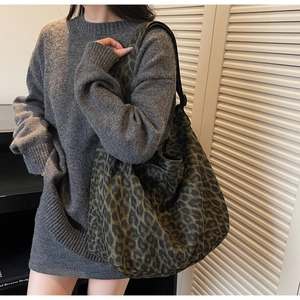Détail d'un grand sac cabas en toile à imprimé léopard avec large bandoulière sur un mannequin