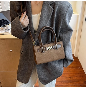 Close-up of brown leopard print suede handbag with metal heart buckle and top handle