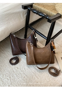 Detail of vintage textured bucket bags with wooden beads and minimalist retro design