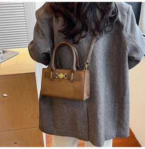 Brown faux suede crossbody bag with vintage gold buckle shown on a model