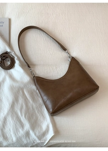 Detailed macro view of retro brown bucket bag with glossy leather texture and dual straps
