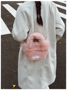 Detail of pink faux fur crossbody bag with chain strap and keep your spirit free text