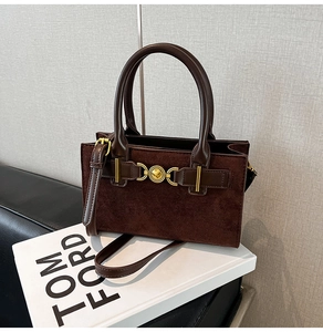 Detail view of coffee tote bag with gold heart buckle and suede leather texture