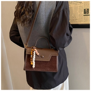 Detailed shot of brown leather crossbody bag with mixed textures and vintage charm