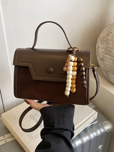 Chic dark brown crossbody bag with wooden bead charm and mixed texture vegan leather