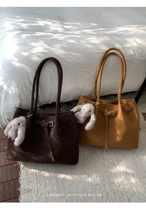 Detail of dark brown and khaki retro tote bags with leather texture and rabbit charm