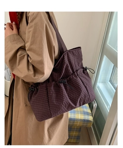 Detail der lila karierten Canvas-Einkaufstasche mit funktionalen Kordelzugtaschen für Alltag
