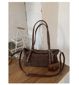 Dettaglio della borsa tote in pelle scamosciata marrone con borchie e mini borsellino