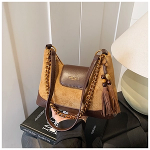 Gros plan d'un sac matelassé en daim marron avec pompons et détails en cuir chic