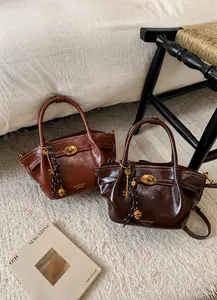 Detailed macro view of vintage leather bucket bags featuring metallic lock and key charms