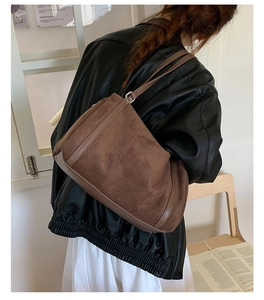 Dettaglio della borsa tote in pelle scamosciata marrone scuro opaca con finiture in pelle