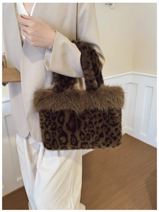Detail of leopard print faux fur handbag with plush trim held by a model in a beige suit
